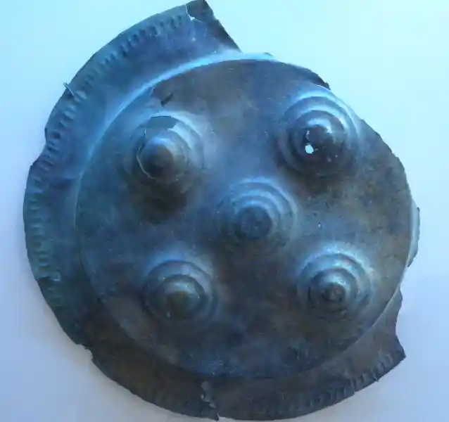 A solar disc with five circles forming a cross inside a circle